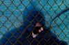 A fans watches through a hole in the fence along the the 12th hole during the first round of the PGA Championship golf tournament at TPC Harding Park Thursday, Aug. 6, 2020, in San Francisco. (AP Photo/Jeff Chiu)