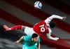 Arsenal's Nicolas Pepe, right, falls over Liverpool's Andrew Robertson during the English Premier League soccer match between Arsenal and Liverpool at the Emirates Stadium in London, England, Saturday, April 3, 2021. (Catherine Ivill/Pool via AP)