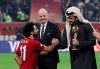 FIFA president Gianni Infantino, center, watches as Sheikh Joaan bin Hamad bin Khalifa Al Thani, right, shake hands with Liverpool's Mohamed Salah, left, during the Club World Cup final soccer match between Liverpool and Flamengo at Khalifa International Stadium in Doha, Qatar, Saturday, Dec. 21, 2019. (AP Photo/Hassan Ammar)