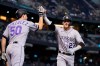 Colorado Rockies' Trevor Story (27) celebrates his two-run home run against the Arizona Diamondbacks with teammate Chi Chi Gonzalez (50) during the third inning of a baseball game Sunday, May 2, 2021, in Phoenix. (AP Photo/Ross D. Franklin)