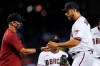 Arizona Diamondbacks starting pitcher Madison Bumgarner, right, hands the baseball over to manager Torey Lovullo as Bumgarner is taken out of the game during the fifth inning of a baseball game against the Oakland Athletics Monday, April 12, 2021, in Phoenix. (AP Photo/Ross D. Franklin)