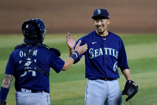 Seattle Mariners relief pitcher Yoshihisa Hirano (6), of Japan, smiles as he celebrates with Mariners catcher Joseph Odom, left, after the final out in the ninth inning of a baseball game against the Arizona Diamondbacks Sunday, Sept. 13, 2020, in Phoenix. (AP Photo/Ross D. Franklin)