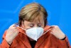 After the switching conference between her and the prime ministers of the federal states, Chancellor Angela Merkel (CDU) adjusts her mask and comments on the further procedure in the Corona crisis at a press conference in the Federal Chancellery, on Sunday, Dec.13, 2020. (Bernd von Jutrczenka/dpa via AP)