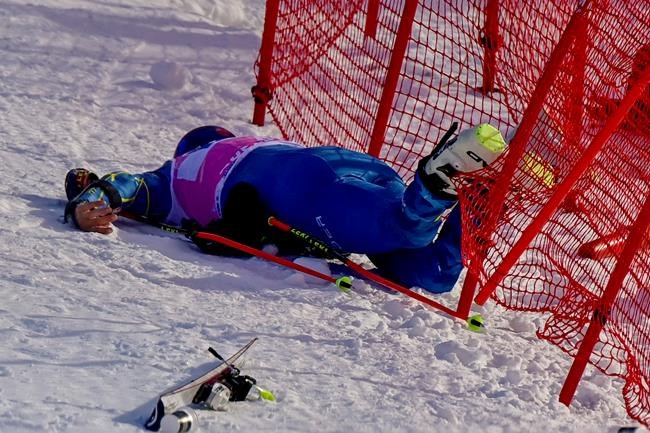 Injured Tommy Ford lies in the net during the first run of the men's giant slalom race at the FIS Alpine Skiing World Cup in Adelboden, Switzerland, Saturday, Jan. 9, 2021. (Jean-Christophe Bott/Keystone via AP)