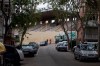 A couple walk past the closed stadium of Spanish 2nd division club Rayo Vallecano in Madrid, Spain, Thursday May 14, 2020. Soccer players in Spain are currently allowed to undergo individual training sessions at their team's training camps, with longer group sessions and full squad practices expected in the coming weeks if the coronavirus pandemic doesn't get worse. La Liga president Javier Tebas has said he hopes the league can restart on June 12. (AP Photo/Paul White)