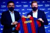 Ronald Koeman, right holds up a soccer shirt with his name on it while standing next to club Director Josep Bartome during his official presentation as coach for FC Barcelona in Barcelona, Spain, Wednesday, Aug. 19, 2020. Barcelona officially announced earlier on Wednesday a deal with Koeman to become their coach five days after the team's humiliating 8-2 loss to Bayern Munich in the Champions League quarterfinals. Barcelona says the former defender's deal runs through June 2022. Koeman replaces the fired Quique Setien. (AP Photo/Joan Monfort)