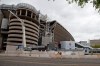Constuction workers stand by Real Madrid's Santiago Bernabeu stadium in Madrid, Spain, Thursday, April 16, 2020. The Covid-19 coronavirus pandemic has affected more than games and player salaries for Real Madrid and Barcelona. It has also taken a toll on their stadium renovation plans. Both Spanish soccer clubs are working on hefty renovation projects for their famed venues.(AP Photo/Paul White)