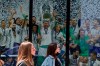 Two women walk past a Real Madrid poster of the team celebrating in a merchandising shop in Madrid, Spain, Monday, April 19, 2021. UEFA president Aleksander Ceferin says players at the 12 clubs setting up their own Super League could be banned from this year's European Championship and next year's World Cup. Ceferin spoke after a UEFA executive committee meeting held only hours of the English, Italian and Spanish clubs announced the project that threatens to split European soccer. (AP Photo/Paul White)