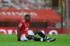 Manchester United's Paul Pogba sits on the ground after getting injured during an English Premier League soccer match between Manchester United and Everton at the Old Trafford stadium in Manchester, England, Saturday Feb. 6, 2021. (Martin Rickett/Pool via AP)