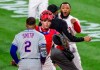 Philadelphia Phillies relief pitcher Jose Alvarado, right, has an altercation with New York Mets' Dominic Smith (2) as catcher Andrew Knapp tries to intervene after Smith struck out swinging in the eighth inning of a baseball game, Friday, April 30, 2021, in Philadelphia. (AP Photo/Laurence Kesterson)