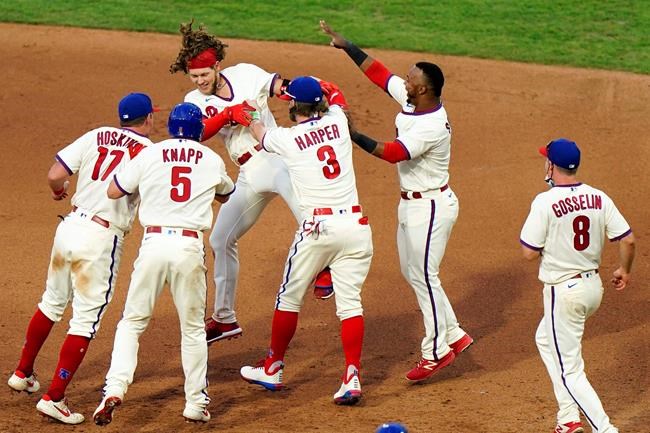 Philadelphia Phillies' Alec Bohm celebrates with teammates after hitting the game-winning two-run single off Boston Red Sox pitcher Matt Barnes during the seventh inning of the first baseball game in a doubleheader, Tuesday, Sept. 8, 2020, in Philadelphia. (AP Photo/Matt Slocum)