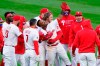 Philadelphia Phillies' Jean Segura, center, celebrates with teammates after hitting a game-winning RBI-single off Atlanta Braves relief pitcher Nate Jones during the 10th inning of an opening day baseball game, Thursday, April 1, 2021, in Philadelphia. (AP Photo/Matt Slocum)
