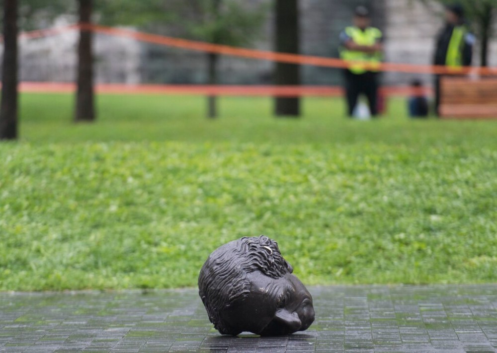 The head of the statue of John A. MacDonald lies on the ground after the statue was torn down by protesters in Montreal. (Graham Hughes / The Canadian Press files)