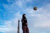 A young man wears a mask to protect against the spread of the coronavirus as he plays with a soccer ball along the Trocadero square close to the Eiffel Tower in Paris, Saturday May 2, 2020 in Paris. France continues to be under an extended stay-at-home order until May 11 in an attempt to slow the spread of the COVID-19 pandemic. (AP Photo/Rafael Yahgobzadeh)