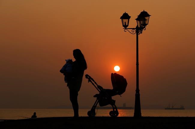 A mother and her son are silhouetted against the last sunset in year 2013 in Hong Kong Tuesday, Dec. 31, 2013. They say a mother's hug lasts long after she lets go. Researchers can now see the lasting imprints of this love in their labs, gaining new insight into the long-held belief that warm and nurturing care from birth is good for babies. THE CANADIAN PRESS/AP/Kin Cheung
