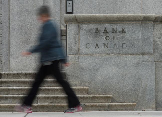 A woman walks past the Bank of Canada bulding in Ottawa, Wednesday September 6, 2017. The Bank of Canada is cutting its key interest target by half a percentage point to 0.25 per cent in an unscheduled rate announcement. THE CANADIAN PRESS/Adrian Wyld