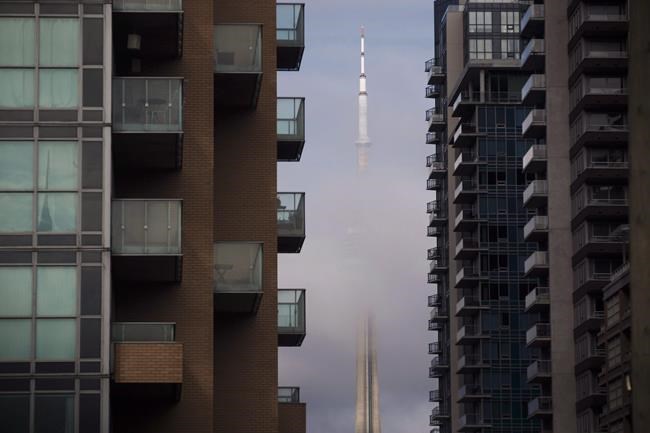 The CN Tower can be seen behind condos in Toronto's Liberty Village community in Toronto on Tuesday, April 25, 2017. The Toronto Regional Real Estate Board says condominium apartment sales in the region have been halved since last year, but the average selling price was up. THE CANADIAN PRESS/Cole Burston