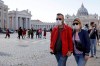 FILE - In this Thursday, Feb. 27, 2020 file photo, a couple wearing face masks stroll outside St. Peter's Square, at the Vatican. A U.S. government advisory urging Americans to reconsider travel to Italy is the ‘’final blow'' to the nation's tourism industry due to a new virus, the head of Italy's hotel federation said Saturday, Feb. 29, 2020. (AP Photo/Gregorio Borgia, file)