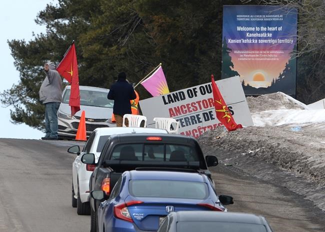 Protesters let vehicles past a check point on a highway in Kanesatake Mohawk Territory, near Oka, Que. on Tuesday, Feb. 25, 2020, as they protest in solidarity with Wet'suwet'en Nation hereditary chiefs attempting to halt construction of a natural gas pipeline on their traditional territories. THE CANADIAN PRESS/Ryan Remiorz