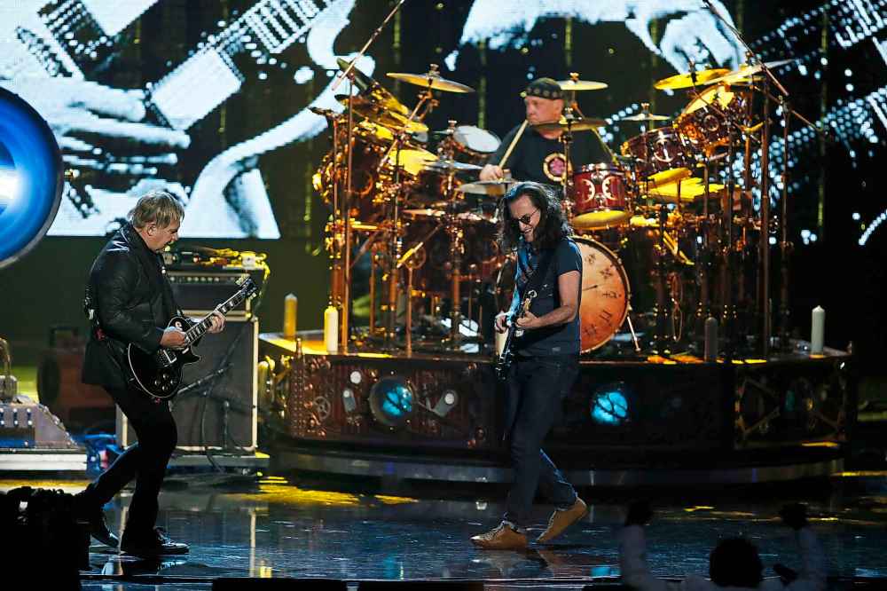 CP
Alex Lifeson (left), Geddy Lee (centre) and Neil Peart (rear) of Rush perform as their band is inducted into the Rock and Roll Hall of Fame in 2013. (Danny Moloshok / Invision files)