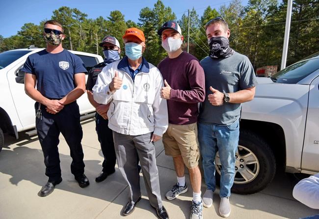 Republican U.S. Sen. Lindsey Graham, center, poses for a photo with Fire Chief Kevin Christenbury, second from right, and fellow firefighters after voting in the general election, Tuesday, Nov. 3, 2020, at the Corinth-Shiloh Fire Dept. in Seneca, S.C. (AP Photo/Richard Shiro)