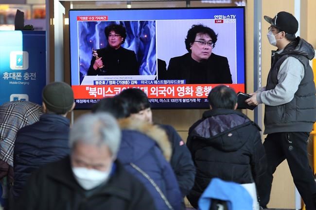 People watch a TV screen showing images of South Korean director Bong Joon Ho during a news program at the Seoul Railway Station in Seoul, South Korea, Monday, Feb. 10, 2020. In a milestone win that instantly expanded the Oscars' horizons, Bong's masterfully devious class satire