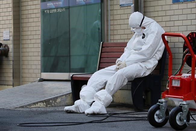 A member of the medical team takes a rest outside a hospital in Daegu, South Korea, Sunday, Feb. 23, 2020. South Korea's president has put his country on its highest alert for infectious diseases, saying Sunday that officials should take