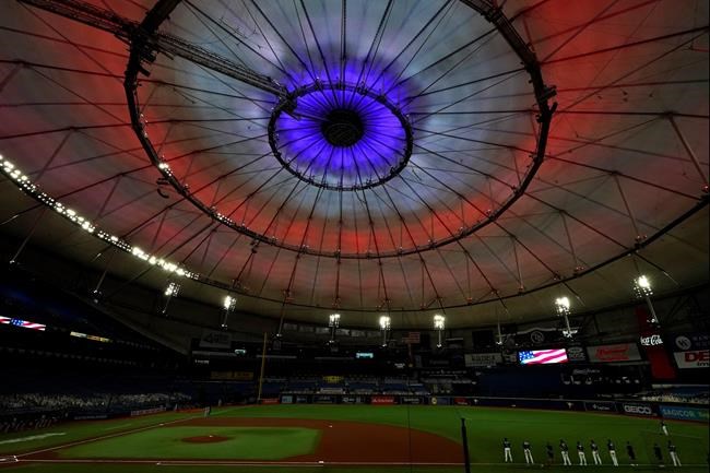 The roof inside Tropicana Field is illuminated red, white, and blue during the playing of the National Anthem before a baseball game between the Tampa Bay Rays and the Boston Red Sox Friday, Sept. 11, 2020, in St. Petersburg, Fla. Today marks the 19th anniversary of the Sept. 11, 2001 terrorist attacks. (AP Photo/Chris O'Meara)