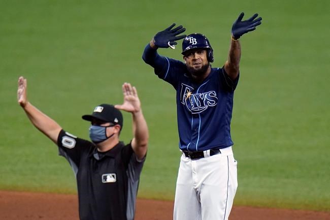 Tampa Bay Rays' Jose Martinez celebrates his two-run double off Toronto Blue Jays starting pitcher Ryan Borucki during the sixth inning of a baseball game Friday, Aug. 21, 2020, in St. Petersburg, Fla. Umpire David Arrieta calls time. (AP Photo/Chris O'Meara)