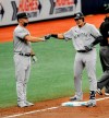 New York Yankees third base coach Phil Nevin, left, congratulates Gio Urshela, right, after two runs scored on an error by Tampa Bay Rays center fielder Manuel Margot during the fifth inning of a baseball game Sunday, Aug. 9, 2020, in St. Petersburg, Fla. (AP Photo/Steve Nesius)