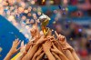 FILE - In this July 7, 2019, file photo, the United States players hold the trophy as they celebrate winning the Women's World Cup final soccer match against The Netherlands at the Stade de Lyon in Decines, outside Lyon, France. The 2023 Women's World Cup will be spread across nine cities in Australia and New Zealand. (AP Photo/Francisco Seco, File)