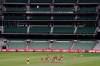 Players from Richmond and Carlton play their Australian Rules Football league game at a empty Melbourne Cricket Ground in Melbourne, Thursday, March 19, 2020, after bans on crowds of more than 500 assembling at outdoor venues amid the coronavirus pandemic. At the MCG less than two weeks ago, more than 86,000 people gathered to watch Australia beat India in the women's Twenty20 Cricket World Cup final. Sports are, evidently, a major part of life in Melbourne, where Aussie rules was invented. (Michael Dodge/AAP Image via AP)
