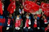 FILE - In this Thursday, March 12, 2020 file photo spectators, some wearing masks because of the coronavirus outbreak, wave Turkish flags prior to a Europa League top 16 first leg soccer match between Basaksehir and Copenhagen, in Istanbul. (AP Photo, File)