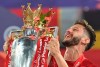 Liverpool's Adam Lallana celebrates with the trophy following the English Premier League soccer match between Liverpool and Chelsea at Anfield Stadium in Liverpool, England, Wednesday, July 22, 2020. Liverpool are champions of the EPL for the season 2019-2020. The trophy is presented at the teams last home game of the season. Liverpool won the match against Chelsea 5-3. (Paul Ellis, Pool via AP)