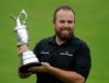 FILE - In this Sunday, July 21, 2019 file photo Ireland's Shane Lowry holds the Claret Jug trophy on the 18th green as he poses for the crowd and media after winning the British Open Golf Championships at Royal Portrush in Northern Ireland. The organizers of the British Open announced Monday April 6, 2020, that they have decided to cancel the event in 2020 due to the current Covid-19 pandemic and that the Championship will next be played at Royal St George's in 2021. (AP Photo/Matt Dunham)