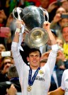FILE - In this Saturday, May 24, 2014 file photo Real's Gareth Bale, lifts the Champion League trophy, at the end of the Champions League final soccer match between Atletico Madrid and Real Madrid, at the Luz stadium, in Lisbon, Portugal. (AP Photo/Manu Fernandez, File)