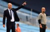 Real Madrid's head coach Zinedine Zidane, left, gestures as he stands alongside Manchester City's head coach Pep Guardiola during the Champions League round of 16, second leg soccer match between Manchester City and Real Madrid at the Etihad Stadium in Manchester, England, Friday, Aug. 7, 2020. (AP Photo/Shaun Botterill, Pool)