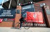 A man cycles past banners outside of Anfield Stadium, Liverpool, England protesting against the clubs decision to join the European Super Leaguer, Tuesday April 20, 2021. Chelsea and Manchester City are preparing to dramatically abandon plans to join a breakaway Super League threatening to implode the project by a group of elite English, Spanish and Italian clubs less than two days after it was announced. (Peter Byrne/PA via AP)