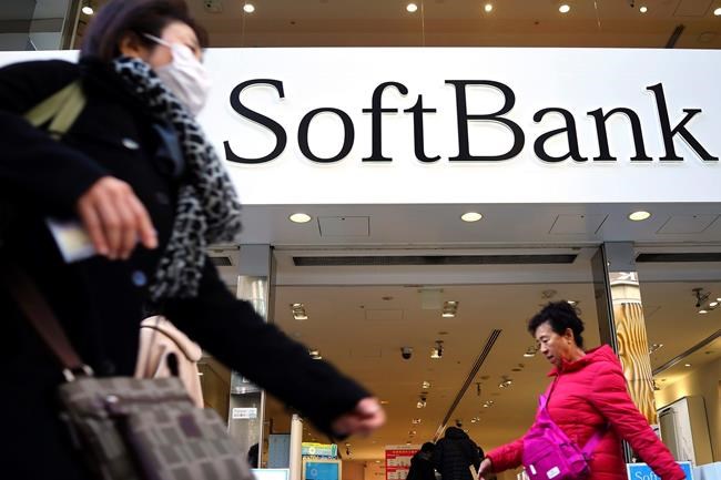 In this Jan. 20, 2020, photo, people walk in front of SoftBank store in Ginza shopping district in Tokyo. Japanese technology conglomerate SoftBank Group Corp. said Wednesday, Feb. 12, 2020 its profit for last quarter dropped amid worries about the perceived risk of its investments into companies like WeWork. (AP Photo/Eugene Hoshiko)