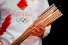 FILE - In this Feb. 24, 2020, file photo, Greek singer Sakis Rouvas wears the uniform of the torch relay runners in Athens, Greece, as he holds the torch of the 2020 Tokyo Olympic Games during a presentation of the torch relay within in Greece. Organizers have talked in detail about plans for the start of next week's Tokyo Olympic torch relay. The message is simple: exercise extreme caution. The start of the relay on March 25 from northeastern Fukushima prefecture kicks off four months of crisscrossing Japan with the torch. The relay will involve 10,000 runners and the chance of spreading COVID-19 across the country is a real threat.(AP Photo/Thanassis Stavrakis, File)