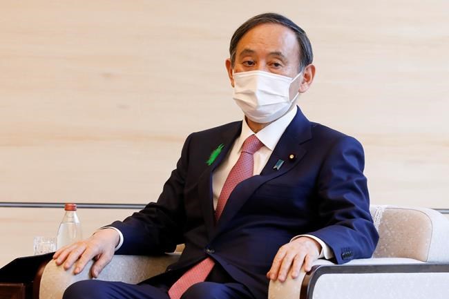 Japan's Prime Minister Yoshihide Suga wearing a face mask meets COP26 President Alok Sharma at the prime minister's official residence Monday, April 19, 2021, in Tokyo, Japan. (Rodrigo Reyes Marin/Pool Photo via AP)