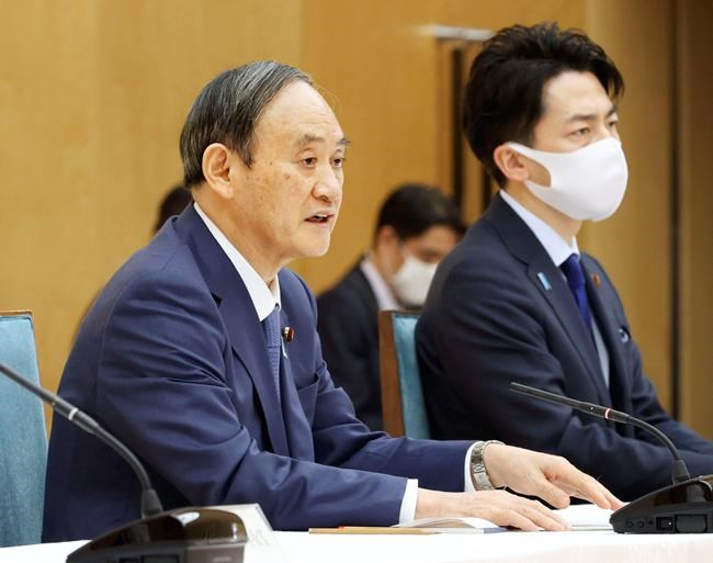 Japanese Prime Minister Yoshihide Suga, left, and Minister of the Environment Shinjiro Koizumi attend the global warming meeting at the prime minister's office in Tokyo, Thursday, April 22, 2021. Japan said Thursday it will raise its greenhouse gas emissions reduction target to 46% on 2013 levels from 26%, NHK television reported. Prime Minister Suga has set a goal to achieve carbon neutrality in Japan by 2050.(Kyodo News via AP)