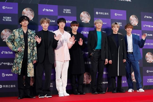 FILE - In this Jan. 5, 2020, file photo, members of South Korean K-Pop group BTS pose for photos during the Golden Disk Awards in Seoul, South Korea. BTS canceled a series of planned concerts in Seoul in April due to concerns about a soaring viral outbreak in South Korea, the band’s management agency said Friday, Feb. 28, 2020. (AP Photo/Ahn Young-joon, File)