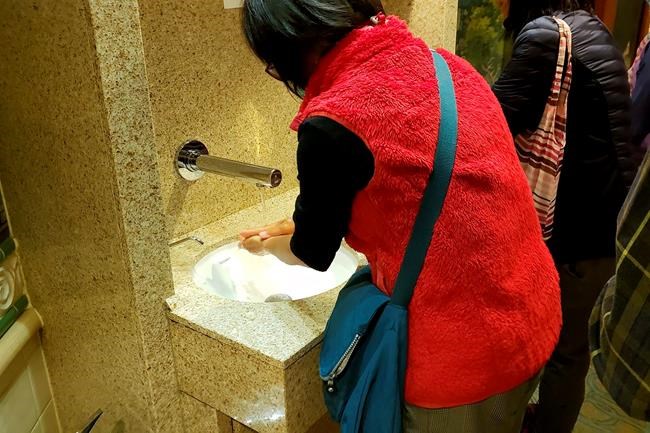In this Monday, Feb. 3, 2020, photo taken by the passenger, another passengers wash their hands on the cruise ship Diamond Princess anchored off Yokohama, south of Tokyo. The 3,700 people on board faced a two-week quarantine in their cabins. Health workers said Thursday, Feb. 6, 2020, 10 more people from the Diamond Princess were confirmed sickened with the virus, in addition to 10 others who tested positive on Wednesday. The 10 were dropped off as the ship docks and transferred to nearby hospitals for further test and treatment. (@daxa_tw via AP)