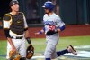 Los Angeles Dodgers' Mookie Betts (50) scores on a throwing error by San Diego Padres' Fernando Tatis Jr. during the third inning in Game 3 of a baseball National League Division Series Thursday, Oct. 8, 2020, in Arlington, Texas. At left is San Diego Padres catcher Jason Castro. (AP Photo/Tony Gutierrez)