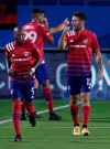 FC Dallas' Ryan Hollingshead, (12) pumps his fist as he reacts to fans as teammate Fafa Picault (9) runs back to set up on defense following Hollingshead's goal during the first half of an MLS soccer game against Sporting KC in Frisco, Texas, Wednesday, Oct. 14, 2020. (Steve Hamm/The Dallas Morning News via AP)
