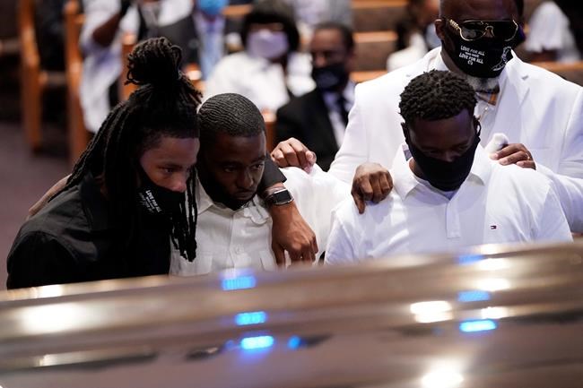 Mourners pause by the casket of George Floyd during a funeral service for Floyd at The Fountain of Praise church Tuesday, June 9, 2020, in Houston. (AP Photo/David J. Phillip, Pool)