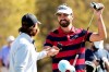 Antoine Rozner, of France, right, bumps fists with Tommy Fleetwood, of England, on the practice green before a practice round for the Dell Technologies Match Play Championship golf tournament Tuesday, March 23, 2021, in Austin, Texas. (AP Photo/David J. Phillip)