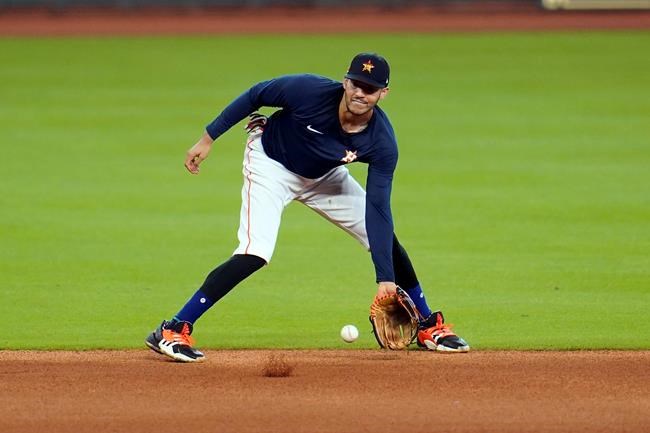 Houston Astros shortstop Carlos Correa fields a ground ball during a baseball practice Wednesday, July 15, 2020, in Houston. (AP Photo/David J. Phillip)