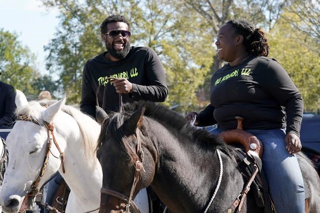 Eboni Price, right, and Cornelius Ates arrive on horseback to vote at a polling site Tuesday, Nov. 3, 2020, in Houston. (AP Photo/David J. Phillip)
